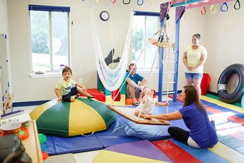 Children and Therapists interacting in a colorful sensory gym