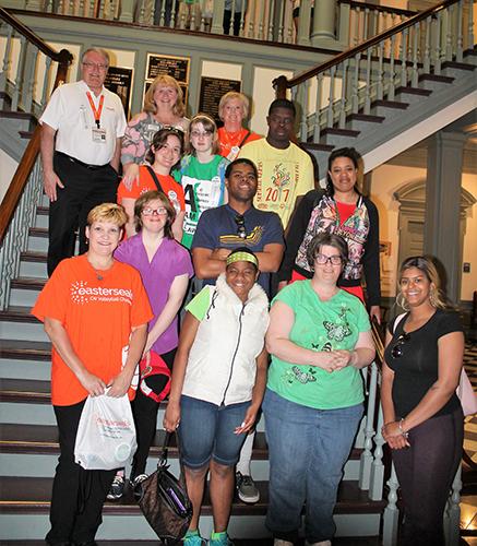 Group of activists stands on the stairs at legislative hall, smiling to camera