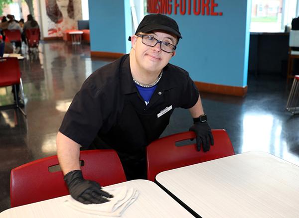 young adult male with down syndrome working in a cafeteria