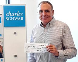 Man presenting a check to the camera