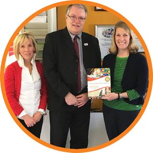 Easterseals Ceo stands next to two women who are holding up an Easterseals sign