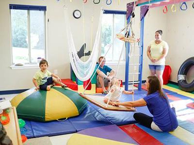 Children and Therapists interacting in a colorful sensory gym