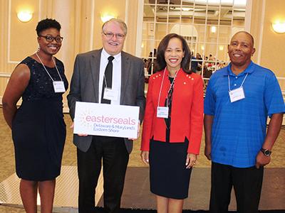 Easterseals CEO and legislators stand with Direct Support Professionals and smile at the camera.