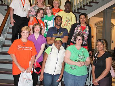 Group of activists stands on the stairs at legislative hall, smiling to camera