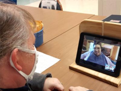 Graphic showing two photographs. two people are talking to each other through a tablet.