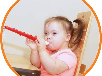 Child with Down syndrome plays music on a recorder