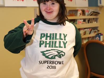 Adult female with down syndrome short brown hair in a philly philly shirt