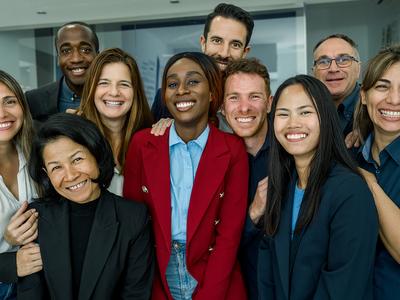 A diverse group of professionals in suits smiling at the camera