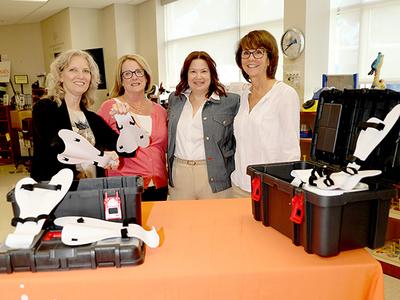 A group of people stand around a table displaying assistive swimming technology.