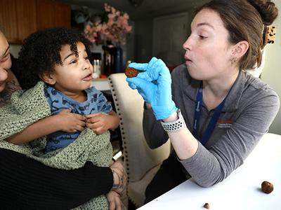 A child in feeding therapy being encouraged by therapist