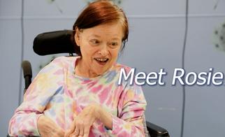 Woman with Cerebral Palsy in brightly colored outfit smiles at camera